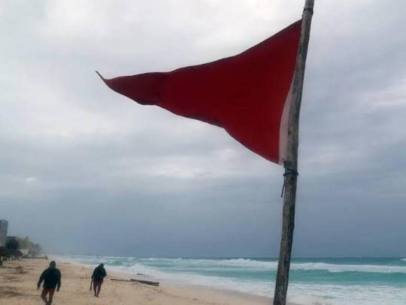Fotografía de archivo de una bandera roja en una playa mexicana que indica oleaje agitado y fuertes corrientes debido a la proximidad de una tormenta.