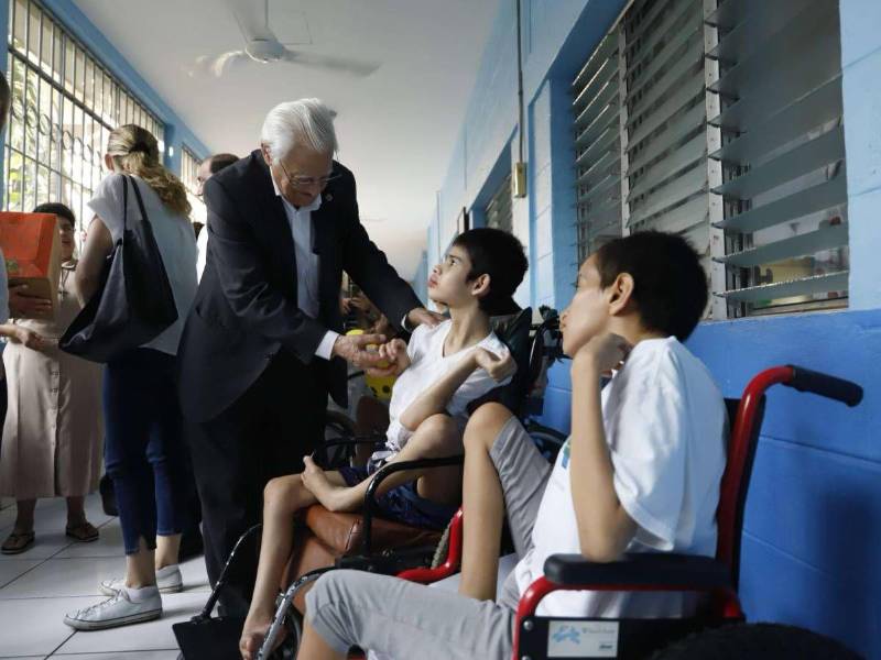 El sacerdote junto a niños beneficiados por las obras de la fundación.