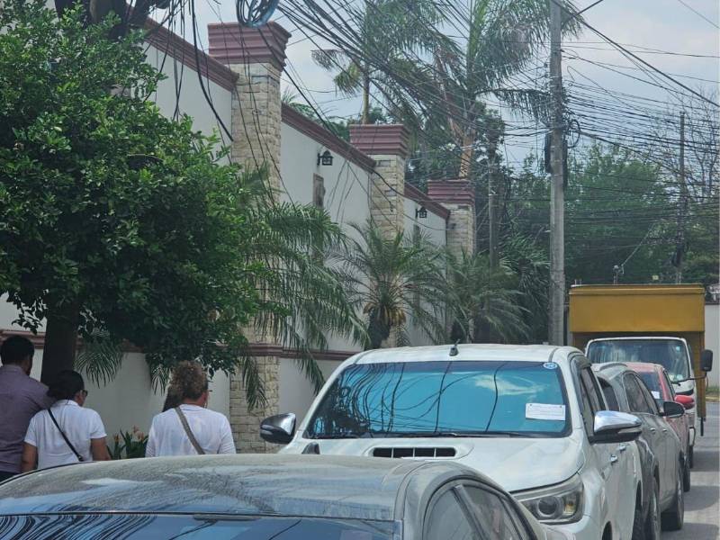 Agentes de Tránsito colocaron citatorias a más de 20 vehículos que permanecían estacionados en fila afuera de las oficinas del Instituto Nacional de Migración (INM), en San Pedro Sula.