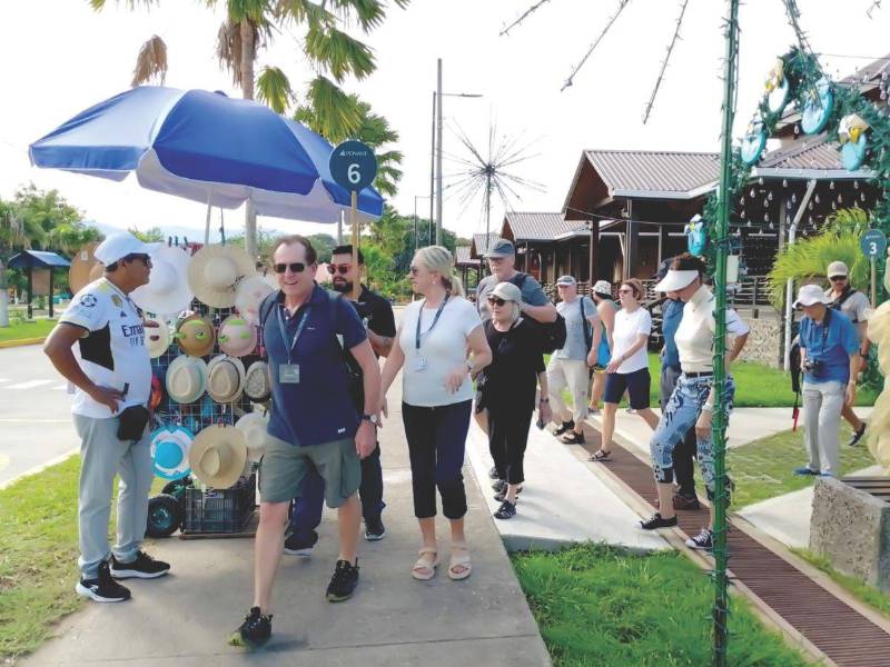 Turistas europeos que llegan a Tela en cruceros de la empresa francesa Ponant caminan por la Plaza Turística Municipal inagurada en septiembre de 2025.