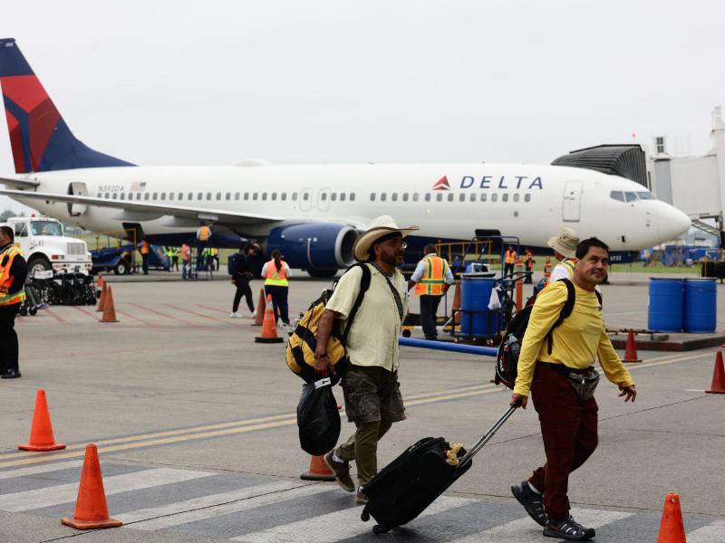 Turistas arriban al aeropuerto Ramón Villeda Morales, mientras aeronave de Delta Airlines utiliza el nuevo puente para el desembarque de pasajeros.