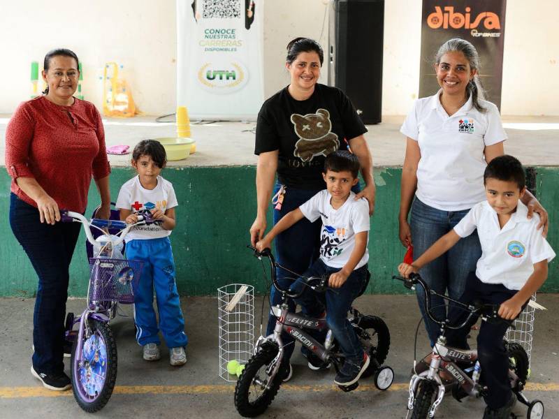 Dibisa entrega premio a tres niños que participaron en una de las actividades acompañados de sus maestras.