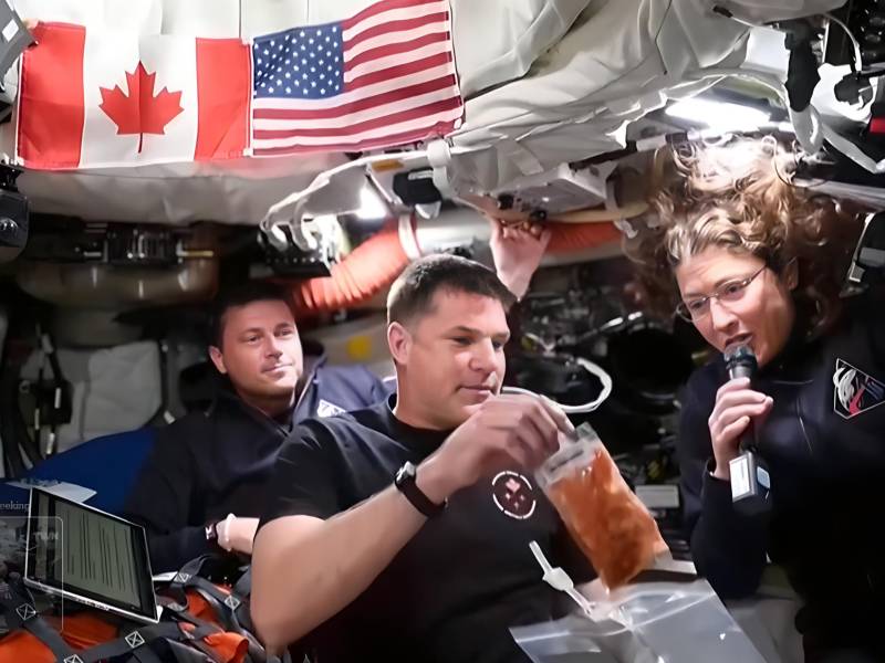 Captura de vídeo de la NASA donde aparecen los astronautas Reid Wiseman (i), Jeremy Hansen (c), y Christina Koch, mostrando los alimentos que consumen a bordo de la nave Orion de la misión lunar Artemis II.
