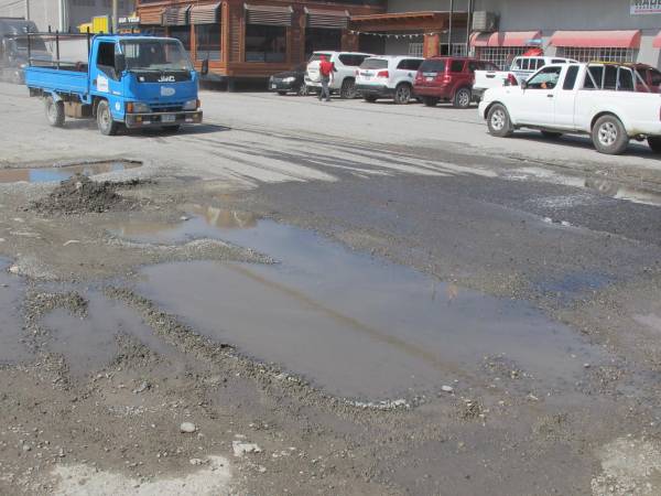 La calle al muelle de cabotaje urge ser reparada. La alcaldía pide sea intervenida lo antes posible, ya que turistas que van a Islas de la Bahía se quejan por el mal estado de la vía.