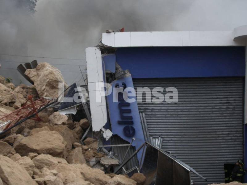 Miembros del Cuerpo de Bomberos trabajan arduamente para llegar a la zona donde se presume están las dos personas atrapadas.