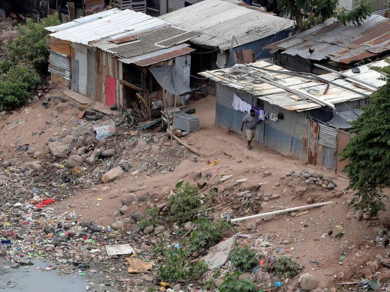 Una persona camina por el barrio Las Brisas a la orilla del rio Choluteca en Tegucigalpa (Honduras).