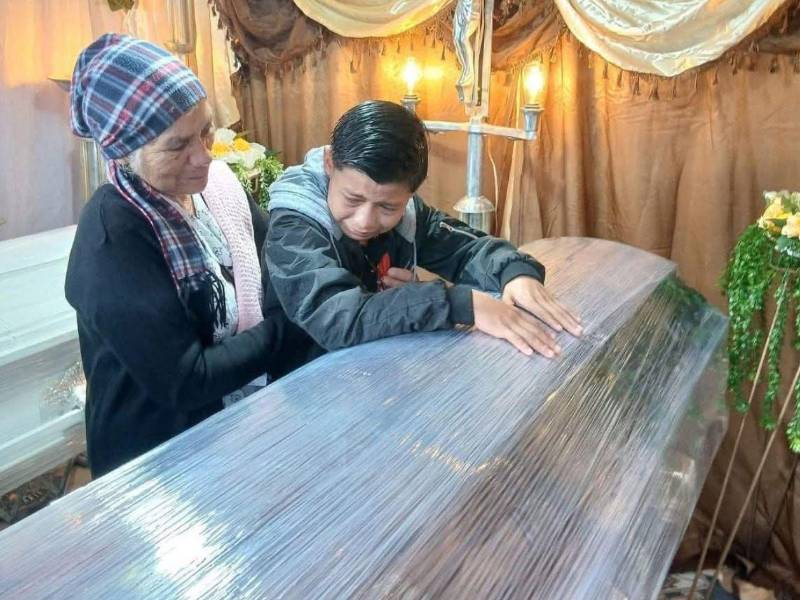 Acompañado de su abuela, el menor Kenneth Alejandro Vásquez, entre lágrimas, se despide este lunes de su madre y hermanito, quienes fallecieron en el accidente de tránsito ocurrido el domingo en Potrerillos, Cortés.