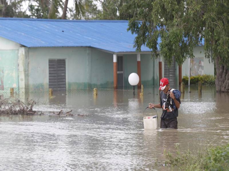 Foto de archivo que muestra a una persona caminando frente a una casa inundada por la crecida de un río en Cuba tras el paso del huracán Melissa. EFE