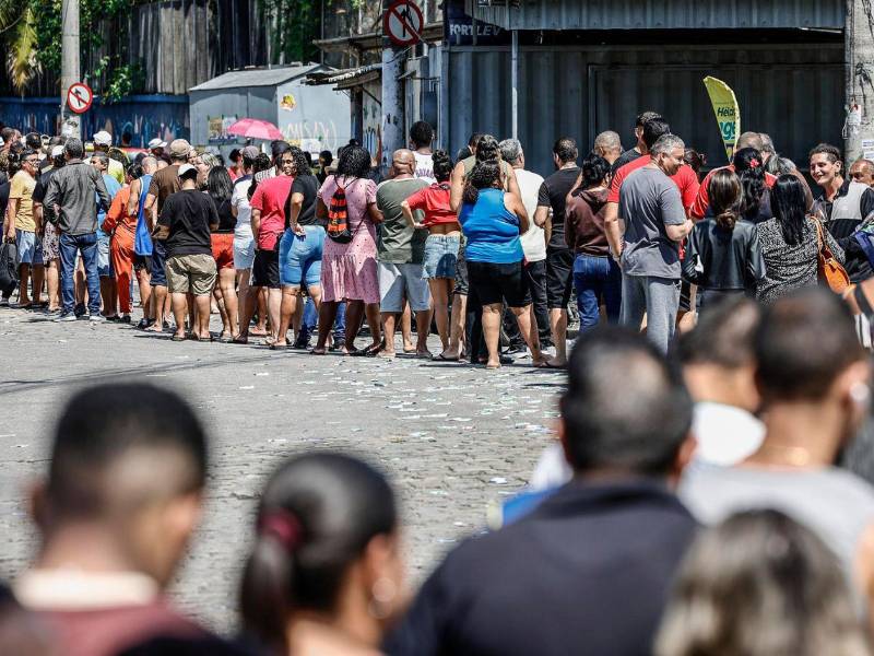 Personas hacen fila en un puesto de votación este domingo, en el barrio de Bonsucesso cerca al complejo de favelas de Maré, en Río de Janeiro (Brasil).