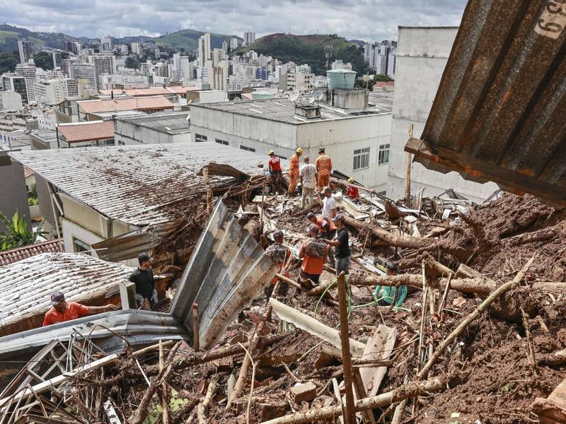 Integrantes del equipo de bomberos y voluntarios remueven escombros durante las labores de rescate en una zona afectada por fuertes lluvias este miércoles, en Juiz de Fora (Brasil).EFE