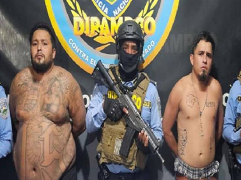 Los dos hombres bajo custodia policial de la Dipampco posan junto a agentes especiales del equipo táctico tras su detención.