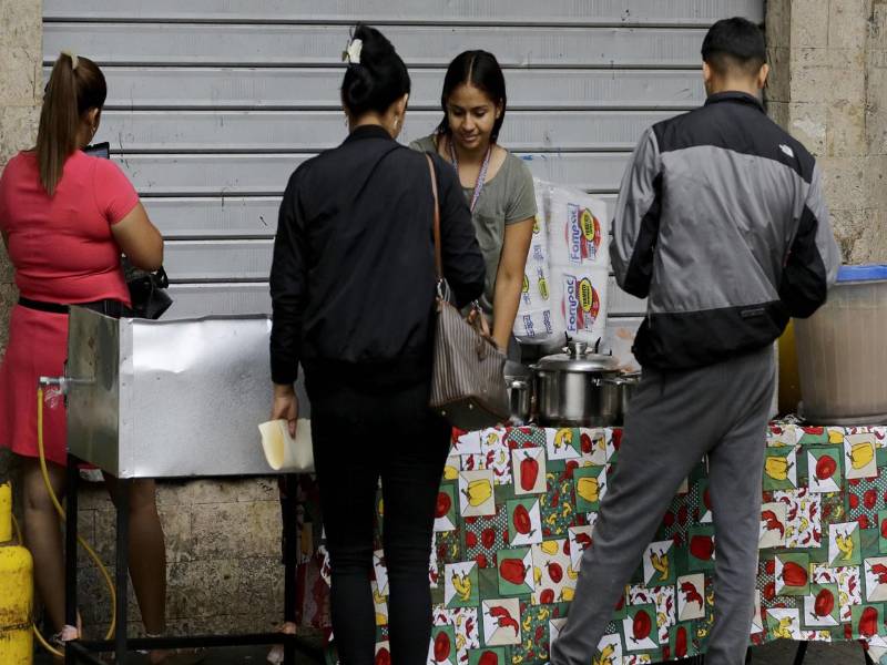 Personas compran alimentos en un puesto de comidas este martes, en Tegucigalpa (Honduras). EFE
