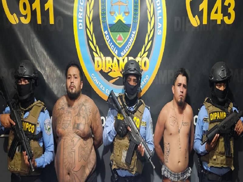 Los dos hombres bajo custodia policial de la Dipampco posan junto a agentes especiales del equipo táctico tras su detención.