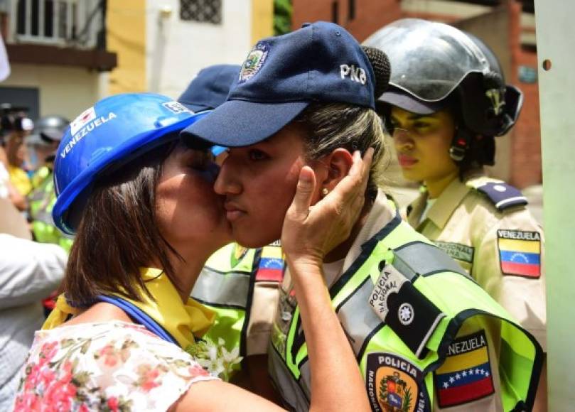 En un gesto de aparente hermandad, la activista besa la mejilla de la oficial de la Policía Nacional Bolivariana.