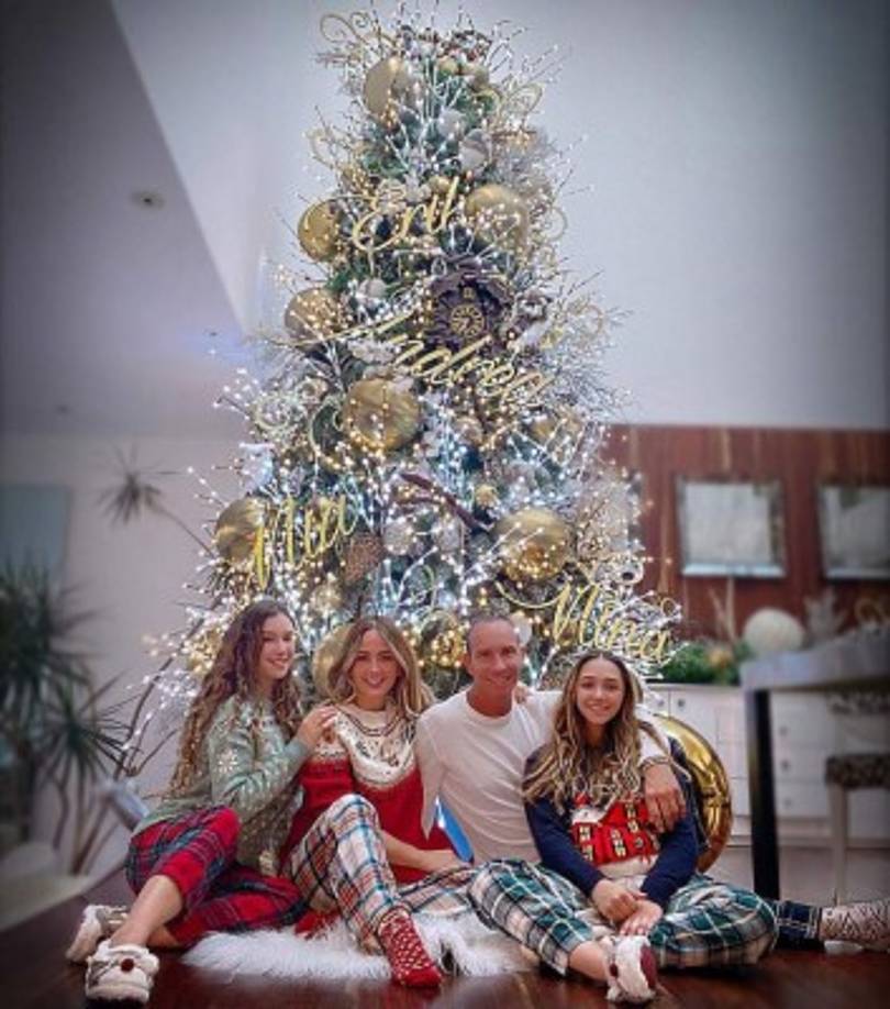 Andrea Legarreta posa con su familia junto al enorme árbol decorado en tonos dorado y plata.