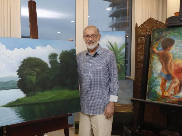 El artista plástico hondureño Marco Rietti junto a algunas de sus obras.