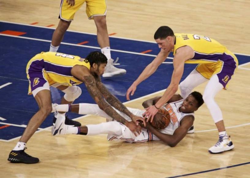 Baloncesto. <br/>Cubriendo el balón. Frank Ntilikina, de los Knicks, mantiene el balón en el suelo ante el acoso de sus rivales de los Lakers en el Madison Square Garden, en Nueva York.