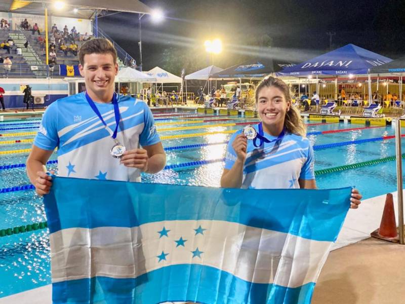 Diego Dulieu y Michell Ramírez posando con las medallas y la bandera de Honduras.