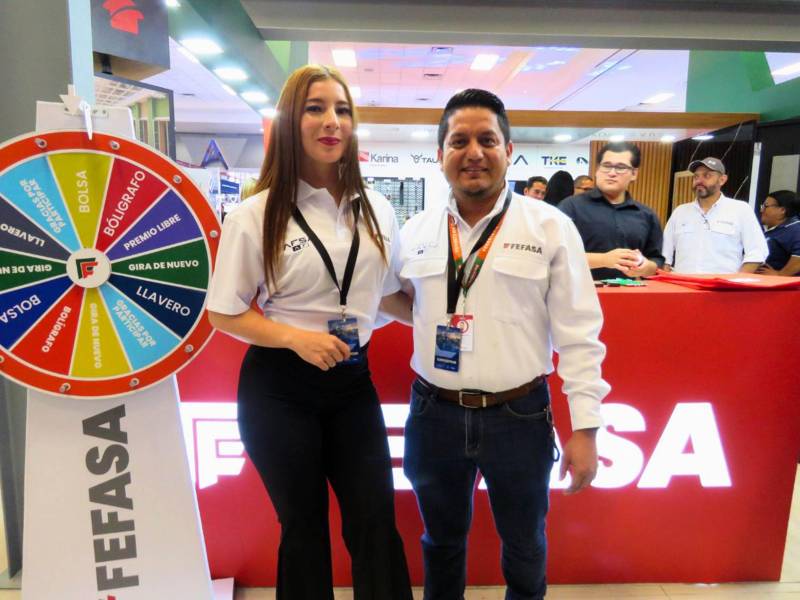 Ronald Mendoza, gerente de Mercadeo de FEFASA, junto a la edecán en el stand en Expoconstruye.