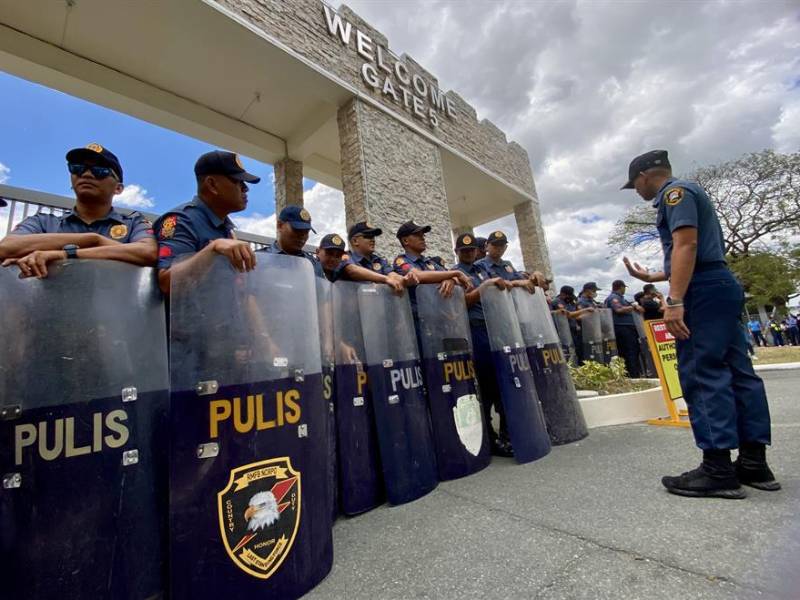 Policías antidisturbios a las puertas de una base aérea militar donde supuestamente está detenido el expresidente Rodrigo Duterte en Manila.