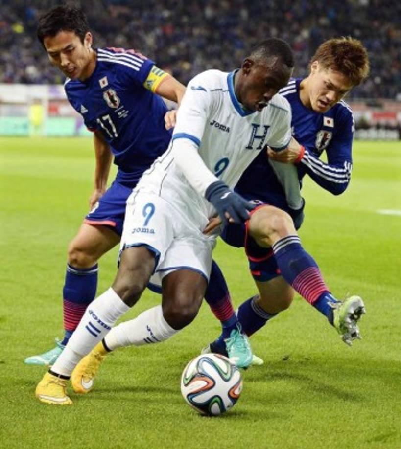 El delantero hondureño Alberth Elis lucha es marcado por los jugadores japoneses Gotoku Sakai (derecha) y Makoto Hasebe.