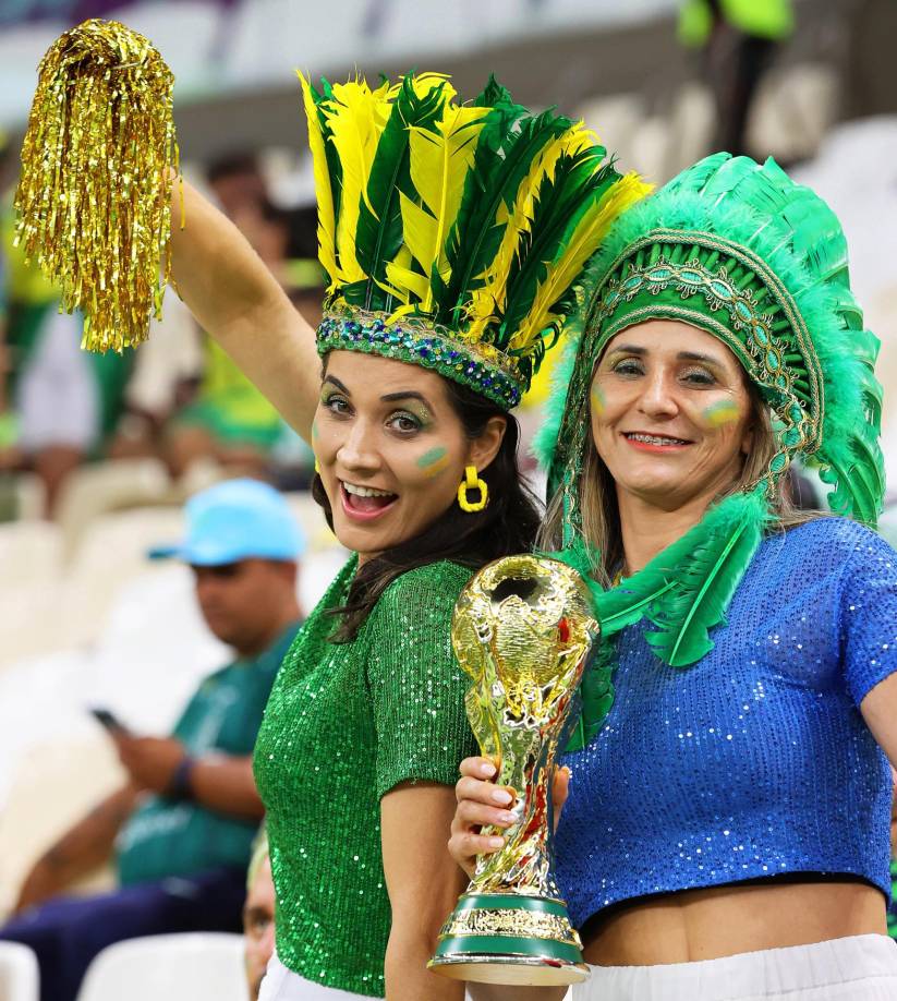 Estas dos chicas posan para el lente en el juego entre Brasil y Camerún.