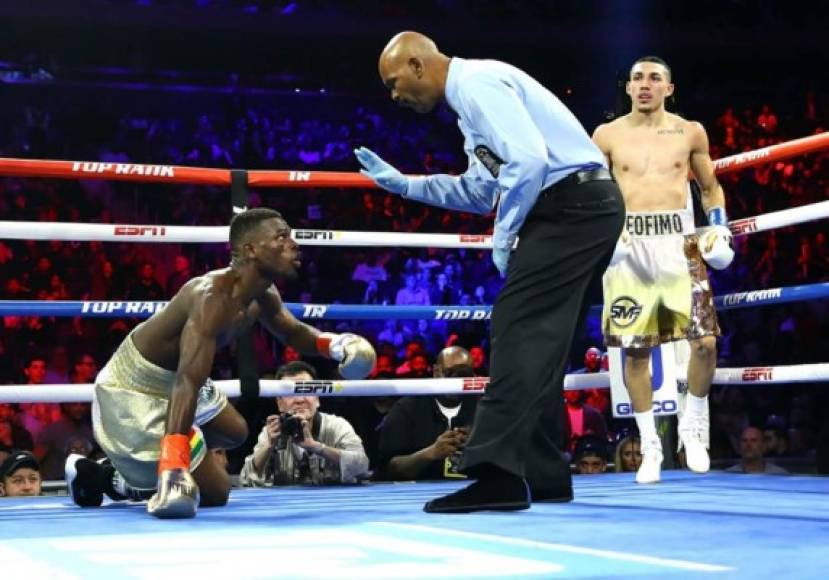 El árbitro de la pelea hablando con Richard Commey, quien estaba en la lona.