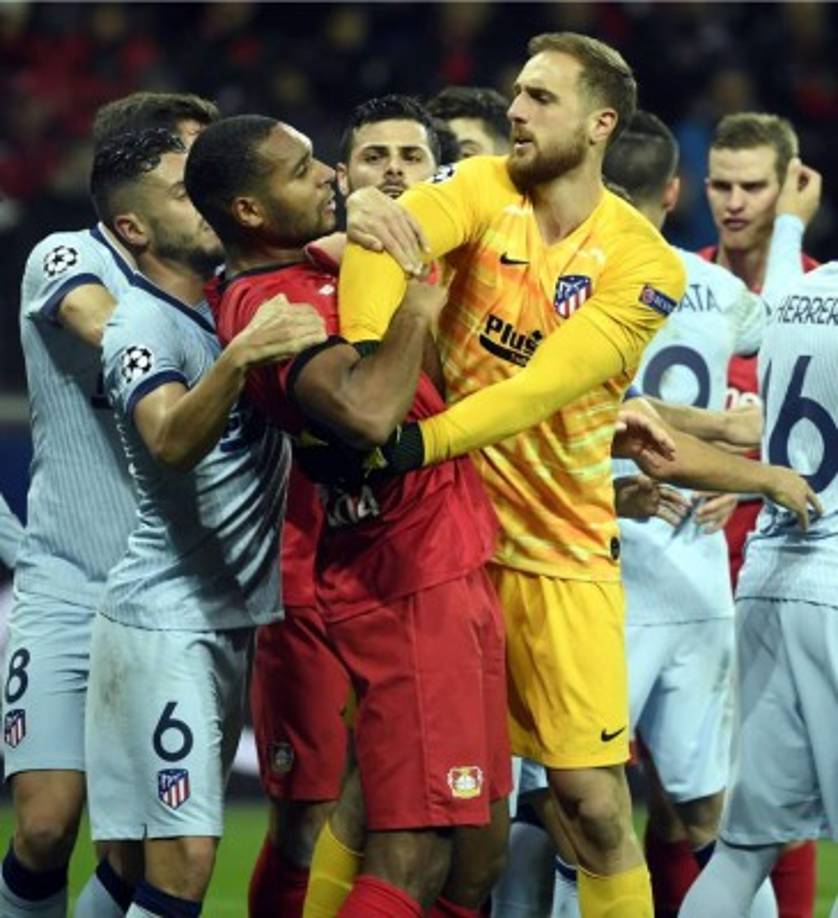 Jan Oblak, portero del Atlético de Madrid, se pelea con el defensa Jonathan Tah del Bayer Leverkusen.