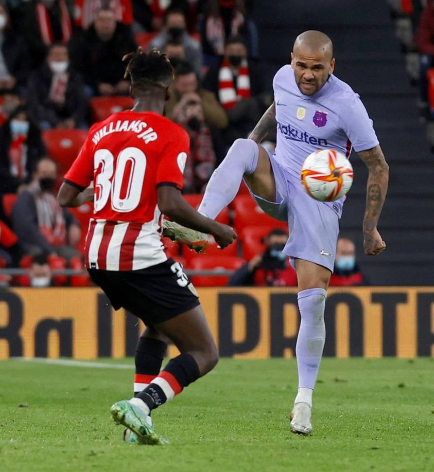 Dani Alves disputando el balón con Nico Williams.