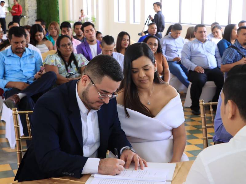 Una pareja firma los documentos legales de su boda.