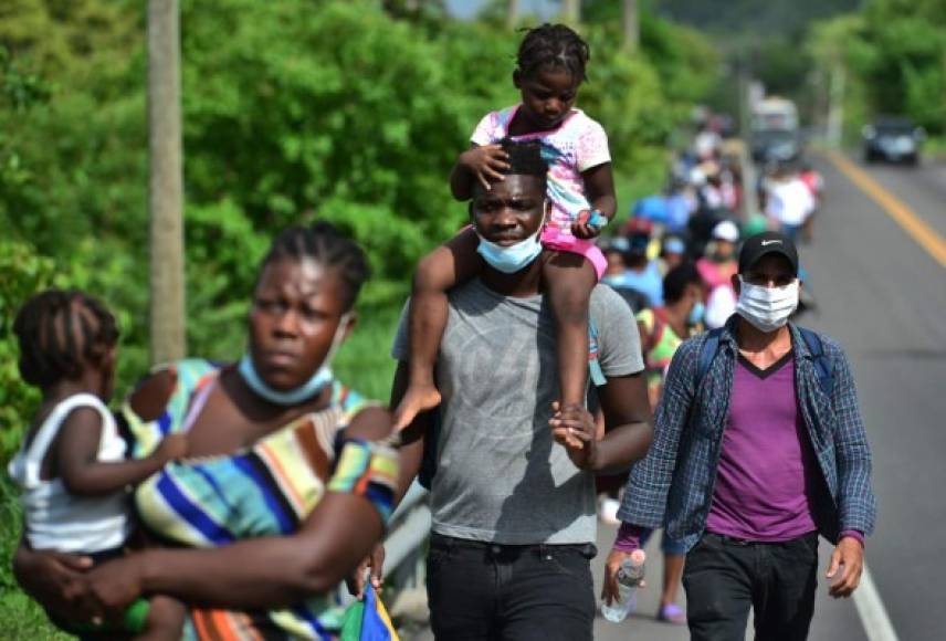 Algunas de las mujeres migrantes, que se cubrían con tapabocas, cargaban niños en brazos.