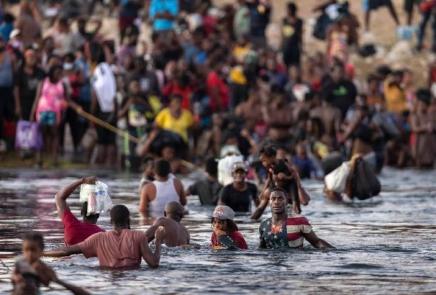 CIUDAD ACUNA, TEXAS - SEPTEMBER 19: Immigrants, mostly from Haiti gather on the bank of the Rio Grande on September 19, 2021 in Ciudad Acuna, Mexico, across the border from Del Rio, Texas. As U.S. immigration authorities began deporting immigrants back to Haiti from Del Rio, thousands more waited in a camp under an international bridge in Del Rio and others crossed the river back into Mexico. John Moore/Getty Images/AFP (Photo by JOHN MOORE / GETTY IMAGES NORTH AMERICA / Getty Images via AFP)