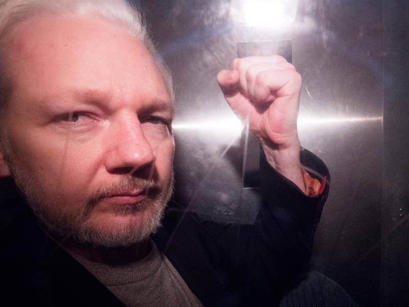 El fundador de Wikileaks, Julian Assange, saluda a los fotógrafos mientras abandona en un vehículo policial, este miércoles, el tribunal de Southwark de Londres (Reino Unido).. EFE/ Neil Hall