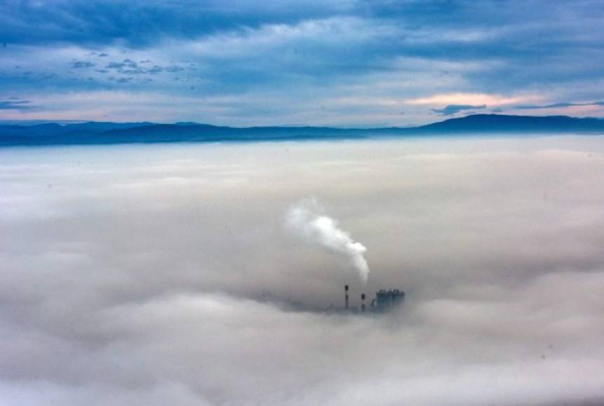 Macedonia. <br/>Contaminación real. El humo de una fábrica se eleva sobre una espesa capa de niebla y contaminación en Skopje