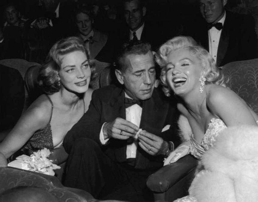 Los actores Lauren Bacall y Humphrey Bogart posan con la actriz Marilyn Monroe.