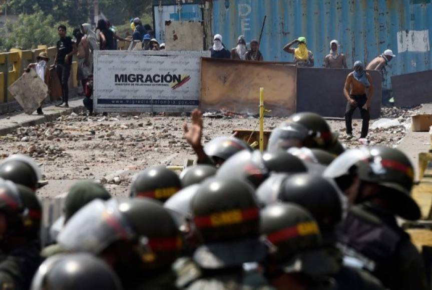 Demonstrators clash with Venezuelan National Guard forces at the Simon Bolivar international bridge -linking Cucuta with Venezuelan city San Antonio del Tachira- in Cucuta, Colombia, on February 24, 2019. - International pressure mounted against Venezuela's leader Nicolas Maduro, with Washington vowing to 'take action' after opposition efforts to bring humanitarian aid into the country descended into bloody chaos. Maduro claims the aid is a smokescreen for a US invasion, and has ordered several crossings on Venezuela's borders with Colombia and Brazil closed. (Photo by Federico Parra / AFP)