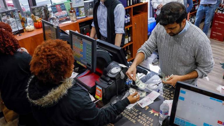 Ciudadanos compran boletos de lotería en una tienda.