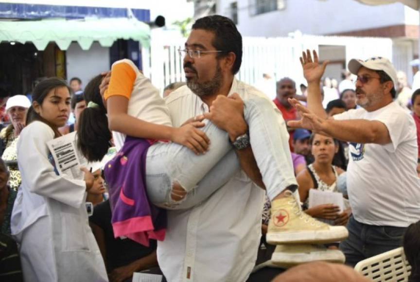 Entre el tumulto, un grupo de voluntarios intentaba abrirle paso a una joven que se desmayó. 'Tenía dos días sin comer', comentó el parlamentario opositor Winston Flores, quien la cargó hasta una camilla.