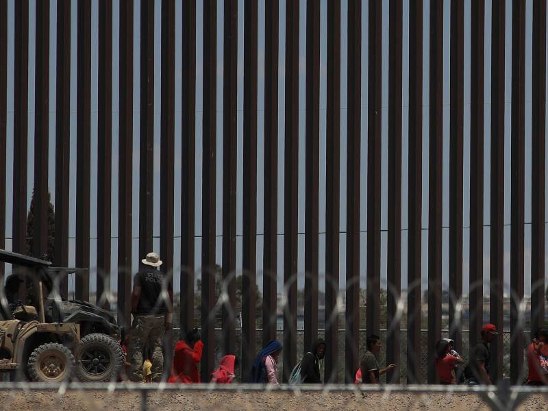 Policías de la Guardia Nacional de Texas dialogan por medio de altavoces con migrantes este viernes, en el muro que divide a México con Estados Unidos, en Ciudad Juárez (México).
