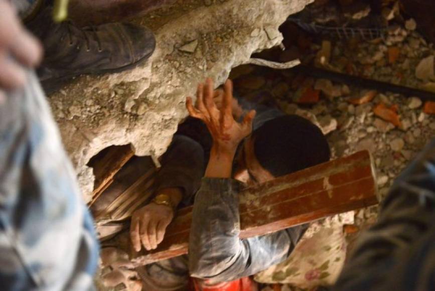 Un grupo de socorristas trabaja en el rescate de uno de los supervivientes entre los escombros de un edificio en Nepal.