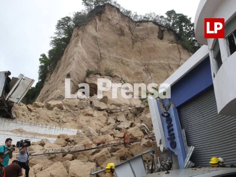 Elementos del Cuerpo de Bomberos mantienen las labores de búsqueda y rescate entre los escombros de las bodegas afectadas por el derrumbe e incendio ocurrido en el anillo periférico de Tegucigalpa.