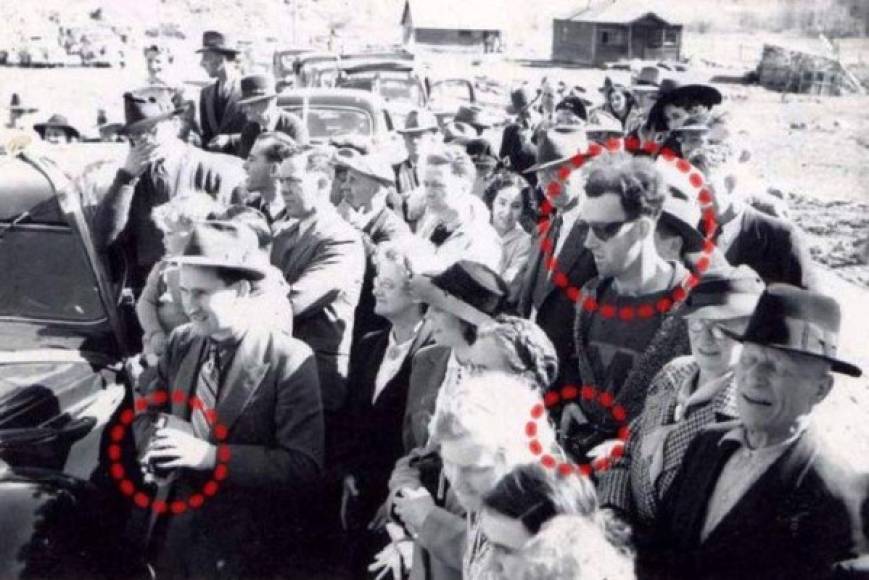 Esta foto fue tomada en el año 1941, en la reapertura del South Forks Bridge, un puente de Canadá. A primera vista parece simplemente una imagen más de la época. Pero si miras con detenimiento, hay algo que no está del todo bien. Hay un hombre vestido con ropas modernas entre las demás personas con traje y corbata. También parece que está sosteniendo una cámara.