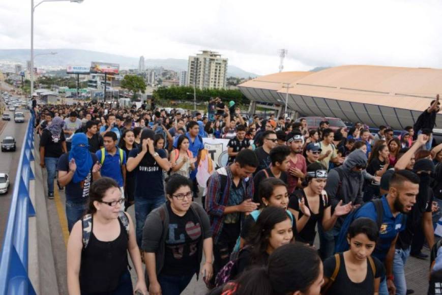 Estudiantes universitarios marchan por el bulevar Suyapa de Tegucigalpa para exigir la renuncia de la rectora Julieta Castellanos. AFP