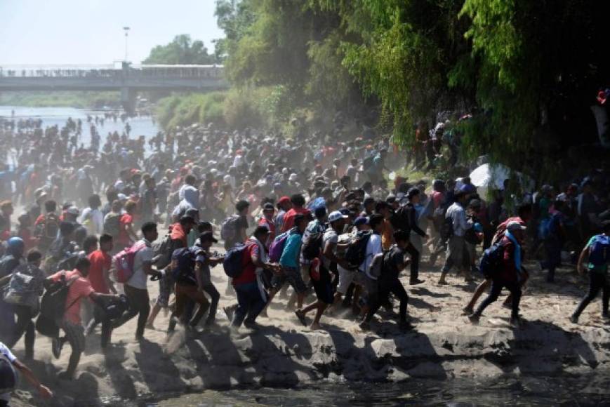 Central American migrants - mostly Hondurans, travelling on caravan to the US- cross the Suichate River, the natural border between Tecum Uman, Guatemala and Ciudad Hidalgo, Mexico, on January 20, 2020 - Hundreds of Central Americans from a new migrant caravan tried to enter Mexico by force Monday by crossing the river that divides the country from Guatemala, prompting the National Guard to fire tear gas, an AFP correspondent said. (Photo by Johan ORDONEZ / AFP)