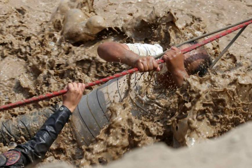 Personal de la policía nacional del Perú ha rescatado a varias personas atrapadas por las inundaciones producidas por el desborde de los ríos Rímac y Huaycoloro en el sector denominado Carapongo al este de la ciudad de Lima (Perú).