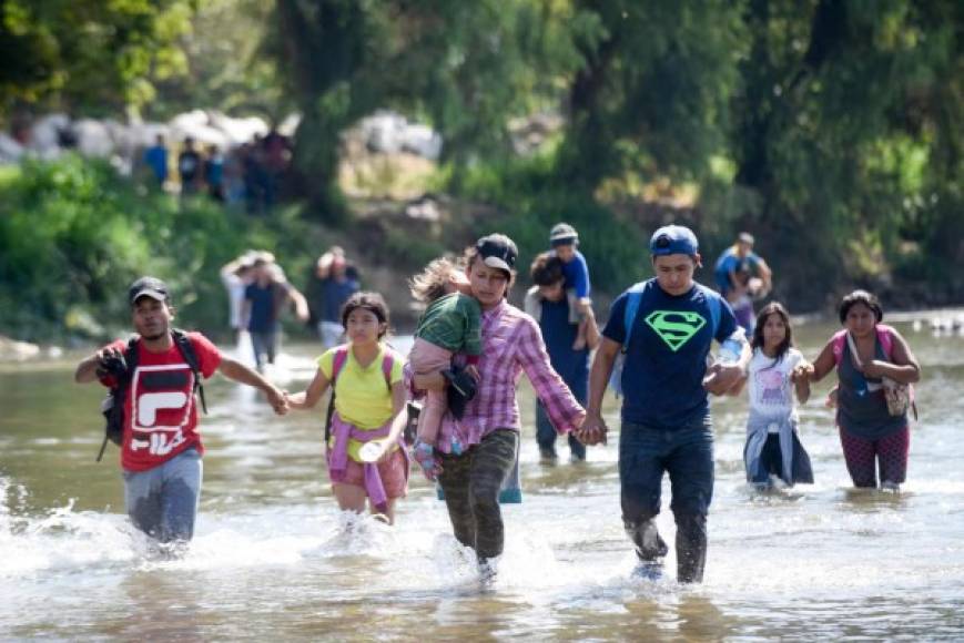 Central American migrants - mostly Hondurans, travelling on caravan to the US- cross the Suichate River, the natural border between Tecum Uman, Guatemala and Ciudad Hidalgo, Mexico, on January 20, 2020 - Hundreds of Central Americans from a new migrant caravan tried to enter Mexico by force Monday by crossing the river that divides the country from Guatemala, prompting the National Guard to fire tear gas, an AFP correspondent said. (Photo by Johan ORDONEZ / AFP)