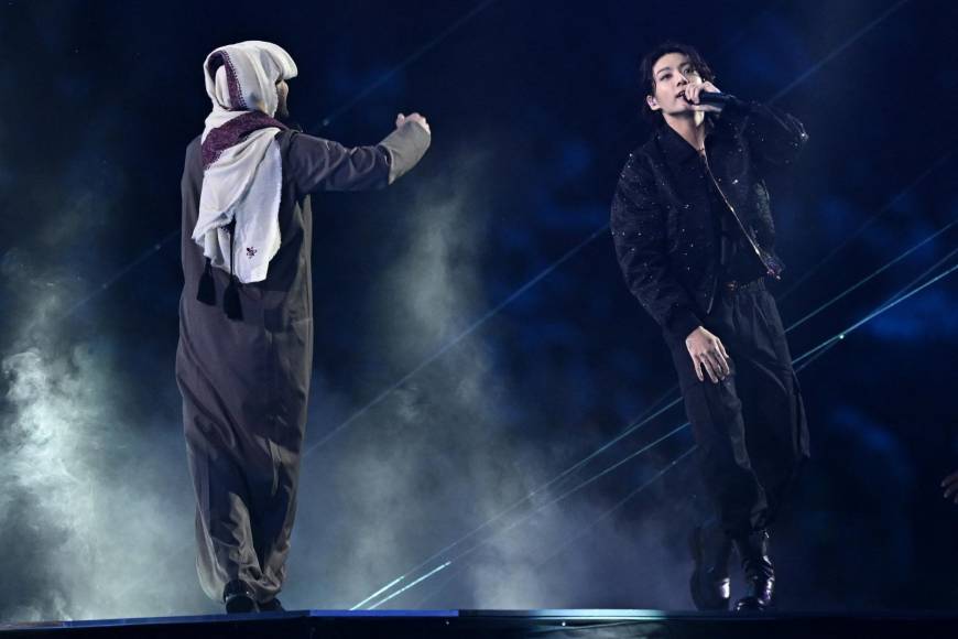 El artista catarí Fahad Al Kubaisi junto al cantante surcoreano Jungkook en la ceremonia de inauguración. 