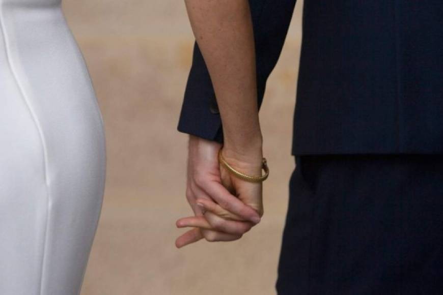 Britain's Prince Harry (R), Duke of Sussex and his wife Meghan, Duchess of Sussex hold hands after posing for photos with Australia's Governor-General and his wife at Admiralty House in Sydney on October 16, 2018. - British royals Harry and Meghan received copious baby gifts, met a koala couple and posed in front of Sydney's dazzling Opera House on October 16, on their first public outing since announcing they are to become parents. (Photo by Steve Christo / POOL / AFP)