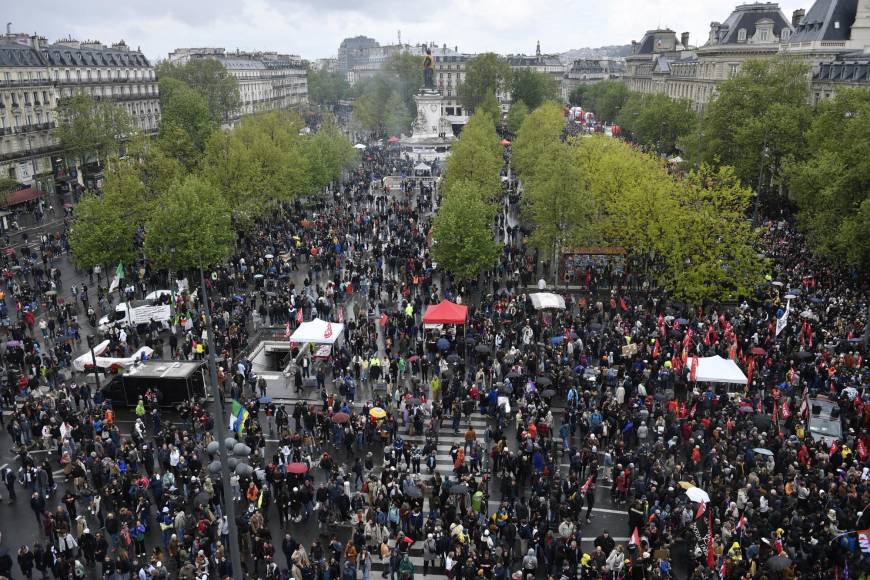 Protesters assemble on Place de la Republique during a demonstration on May Day (Labour Day), to mark the international day of the workers, more than a month after the government pushed an unpopular pensions reform act through parliament, in Paris, on May 1, 2023. - Opposition parties and trade unions have urged protesters to maintain their three-month campaign against the law that will hike the retirement age to 64 from 62. (Photo by JULIEN DE ROSA / AFP)