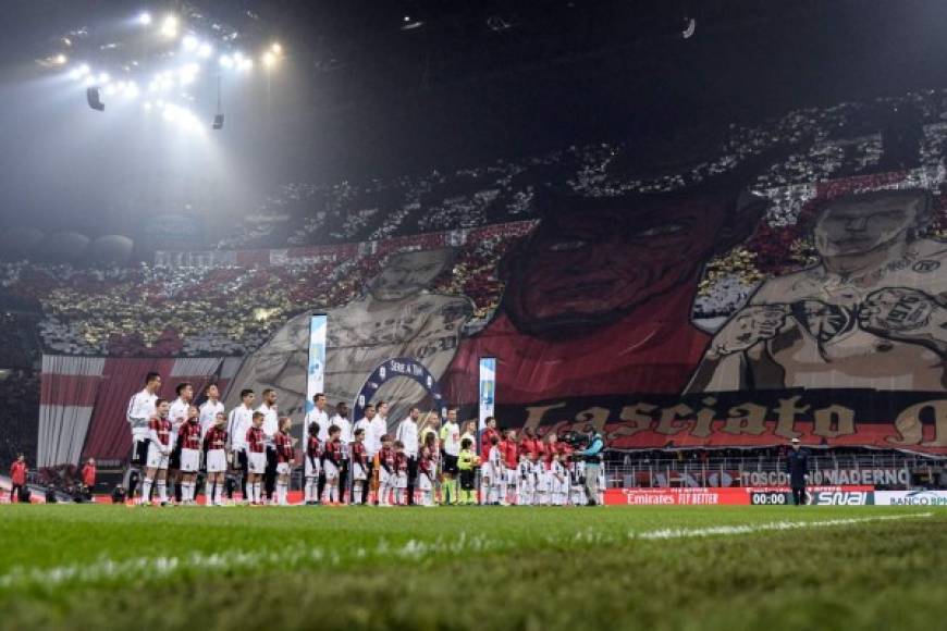 Los equipos titulares de Milan y Juventus ya en el campo de San Siro, con el mosaico de fondo. Foto AFP